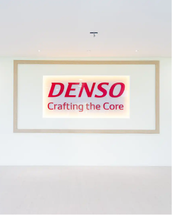 Denso Office — area resepsionis dengan logo bercahaya dan lantai putih minimal